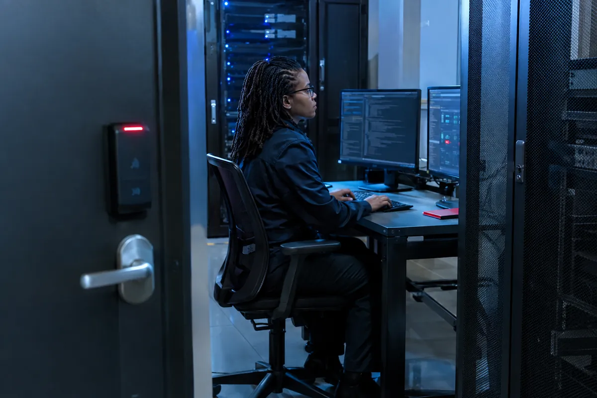 Analyst working in a secured server room with badge access